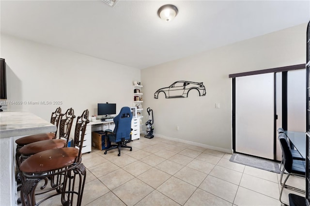 office area featuring baseboards and light tile patterned flooring