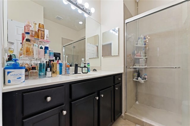 bathroom featuring tile patterned floors, visible vents, a stall shower, and vanity