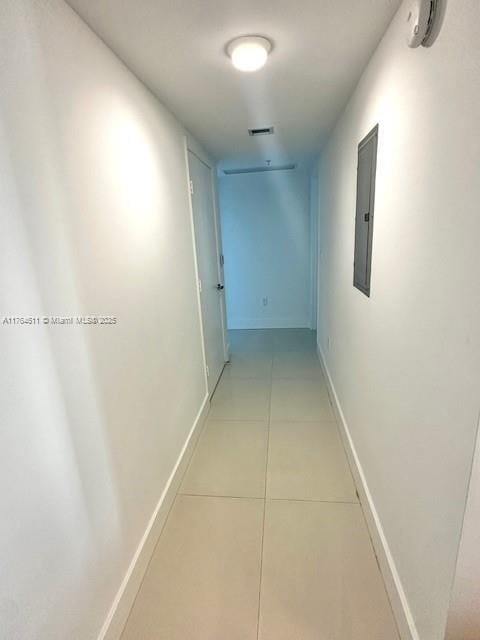 corridor with electric panel, visible vents, baseboards, and light tile patterned floors