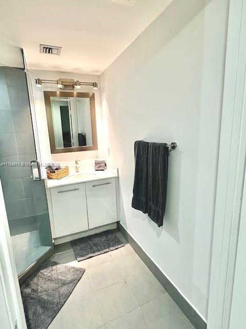 full bathroom featuring vanity, baseboards, visible vents, a stall shower, and tile patterned floors