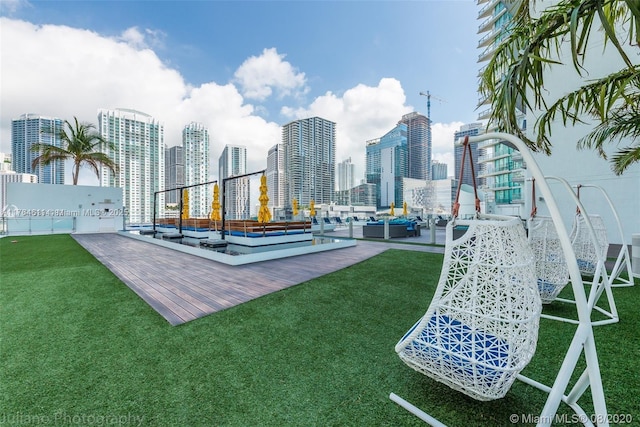 view of community featuring a city view, a lawn, and outdoor lounge area