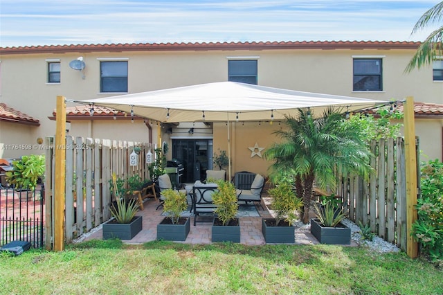 back of property with a fenced backyard, stucco siding, and a patio