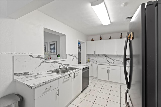 kitchen with visible vents, appliances with stainless steel finishes, light tile patterned flooring, white cabinetry, and a sink