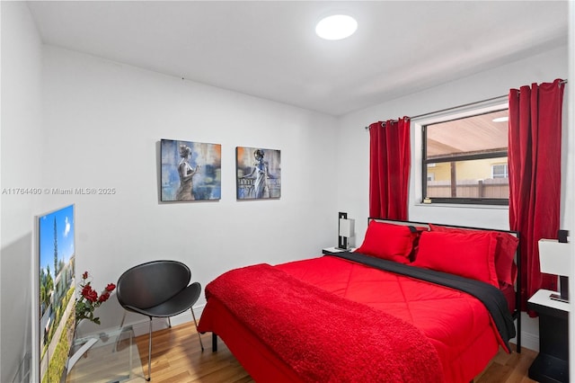 bedroom featuring baseboards and wood finished floors