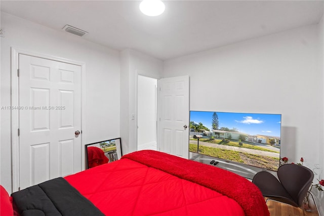 bedroom featuring wood finished floors and visible vents