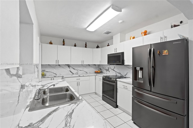 kitchen with a sink, refrigerator with ice dispenser, white cabinets, and electric range oven