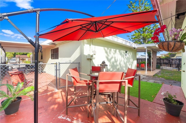 view of patio featuring a gate, outdoor dining area, and fence