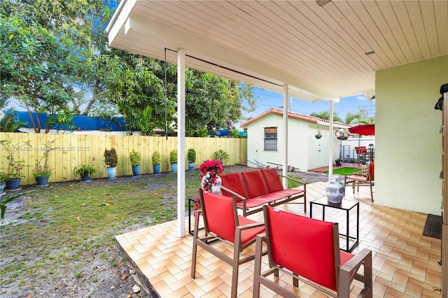 view of patio / terrace with a fenced backyard, an outdoor living space, and an outdoor structure