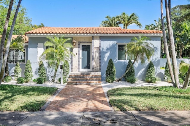 9301 NW 2nd Pl, Miami Shores, FL 33150 - mediterranean / spanish-style house featuring stucco siding, a tile roof, and a front yard