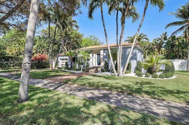 9301 NW 2nd Pl, Miami Shores, FL 33150 - mediterranean / spanish home featuring a front lawn, a tile roof, and stucco siding