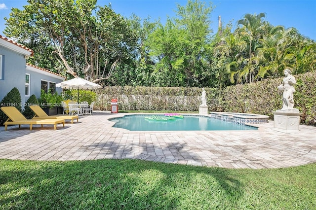 view of swimming pool with a patio, fence, and a pool with connected hot tub