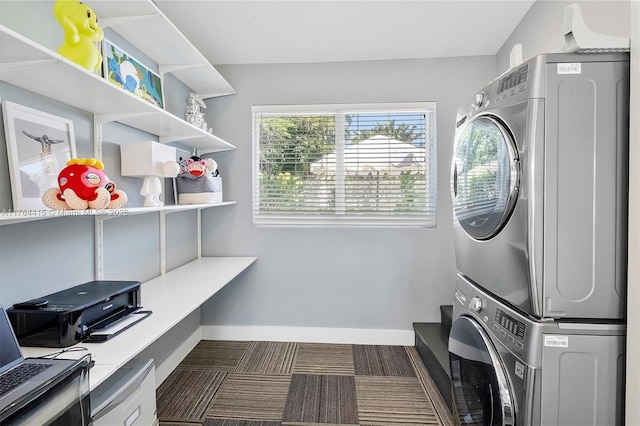 washroom featuring laundry area, plenty of natural light, baseboards, and stacked washer and dryer