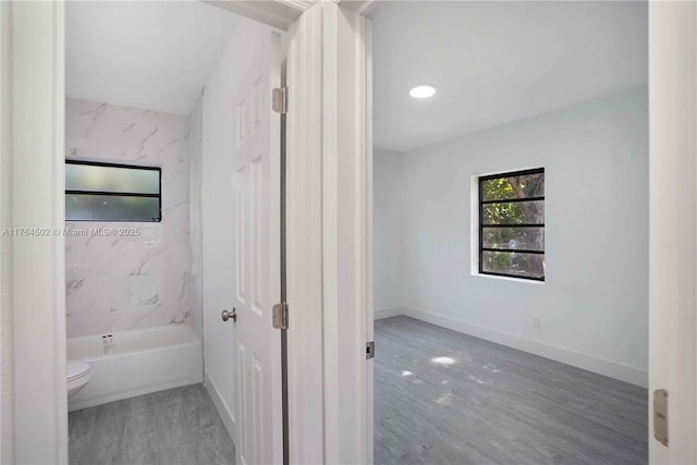 bathroom featuring toilet, baseboards, and wood finished floors