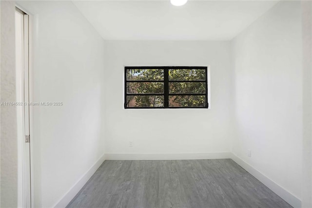 empty room featuring baseboards and wood finished floors