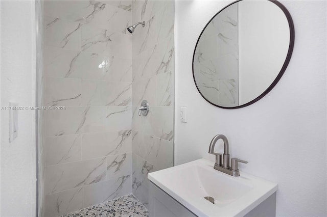 bathroom with vanity and a tile shower