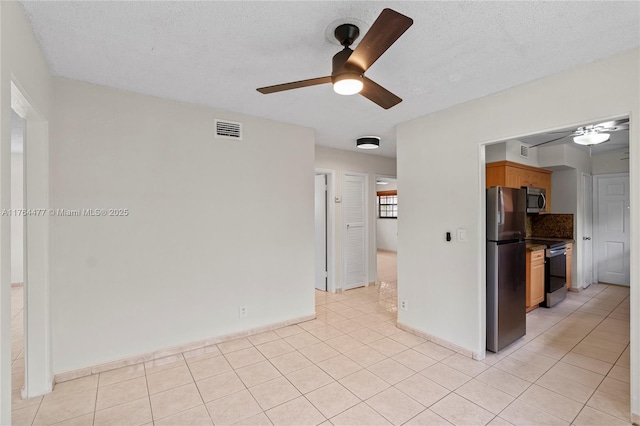 interior space with light tile patterned floors, visible vents, and a ceiling fan