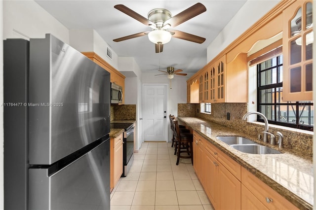 kitchen with visible vents, a ceiling fan, a sink, stainless steel appliances, and light tile patterned flooring