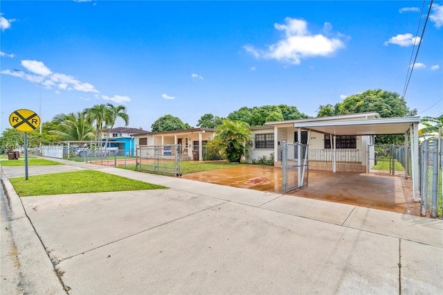 view of front of property featuring a fenced front yard, an attached carport, driveway, and a gate