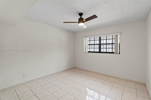 spare room with light tile patterned flooring, a ceiling fan, and a textured ceiling