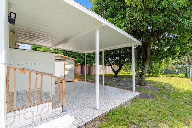 view of patio / terrace featuring an outbuilding, a storage shed, and fence