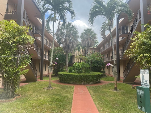 surrounding community with stairway and a lawn