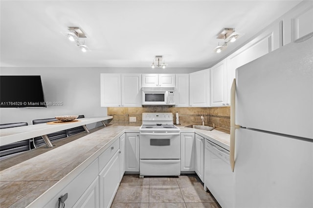 kitchen featuring a sink, white appliances, tasteful backsplash, and white cabinets