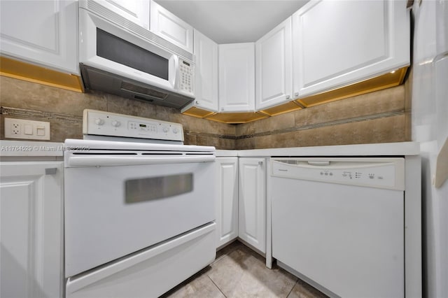 kitchen with light tile patterned floors, white appliances, white cabinetry, and tasteful backsplash