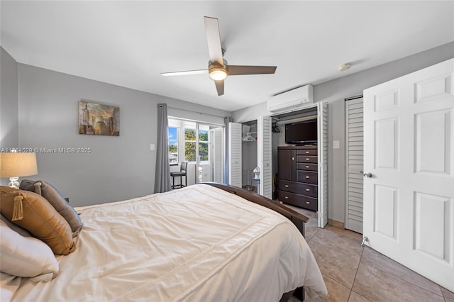 bedroom with ceiling fan, two closets, light tile patterned flooring, and a wall mounted AC