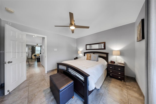 bedroom featuring light tile patterned floors, baseboards, and ceiling fan