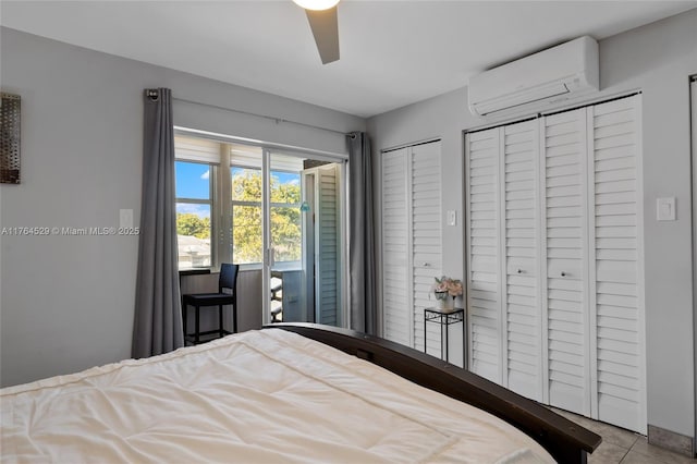 tiled bedroom with ceiling fan, multiple closets, and a wall mounted AC