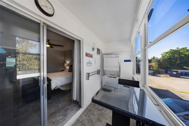 sunroom / solarium featuring a ceiling fan and stacked washing maching and dryer