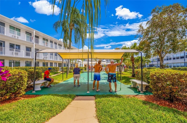 view of home's community featuring shuffleboard and a yard