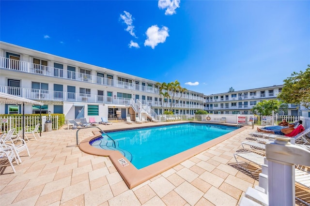 pool with a patio area and fence