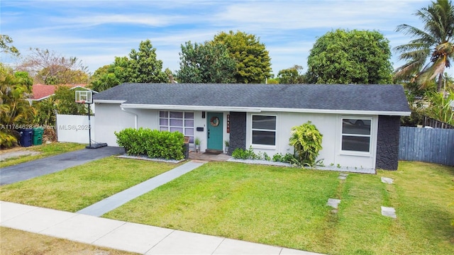 single story home featuring stucco siding, a front yard, and fence