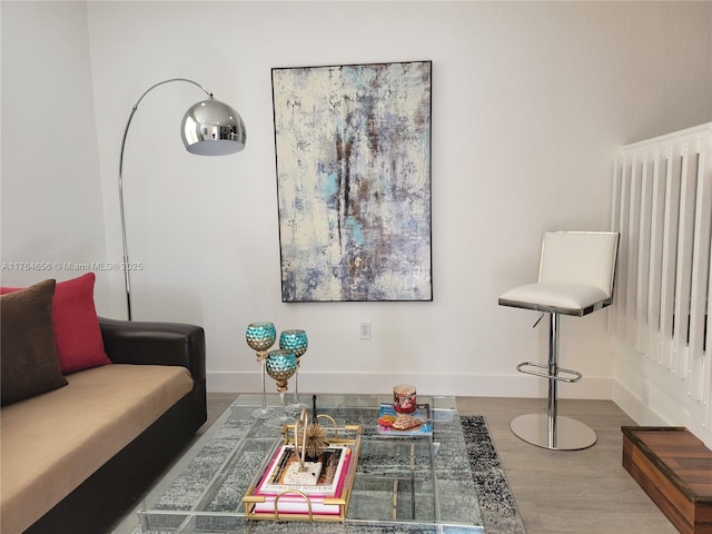 living room with baseboards, wood finished floors, and radiator heating unit