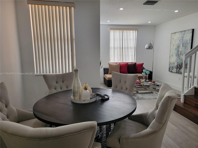 dining area with baseboards, stairway, recessed lighting, wood finished floors, and a textured ceiling