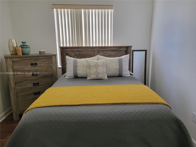 bedroom featuring baseboards and wood finished floors