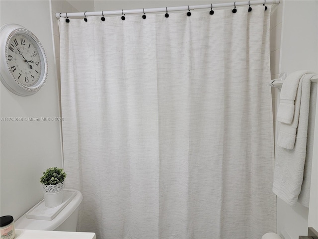 bathroom featuring toilet and a shower with shower curtain