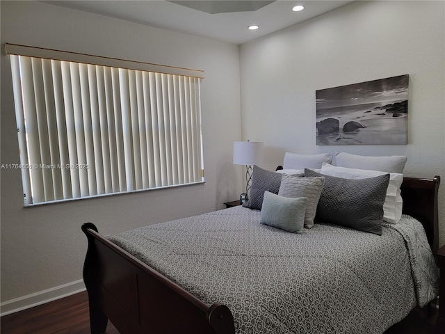 bedroom with dark wood finished floors, recessed lighting, and baseboards