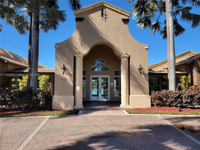 view of exterior entry with french doors and stucco siding