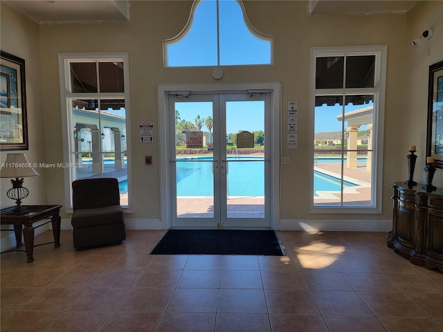 doorway featuring tile patterned floors, french doors, and baseboards