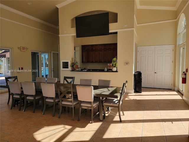 tiled dining area featuring a high ceiling and ornamental molding