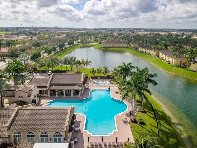 community pool with a patio, a hot tub, and a water view