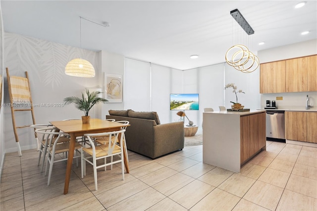 kitchen with modern cabinets, decorative light fixtures, a center island, light countertops, and dishwasher