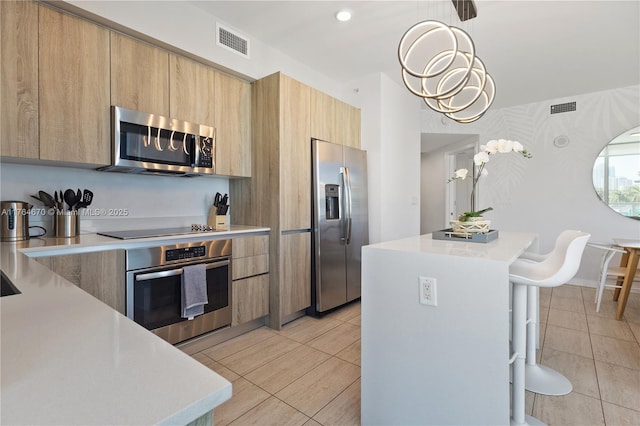 kitchen with modern cabinets, visible vents, appliances with stainless steel finishes, and light countertops