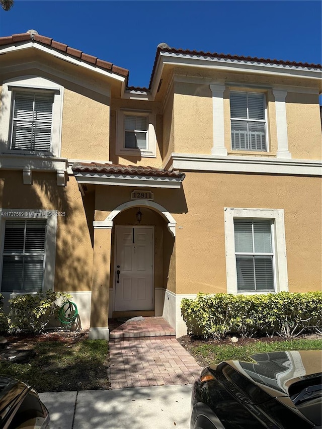 view of front of home featuring stucco siding and a tiled roof