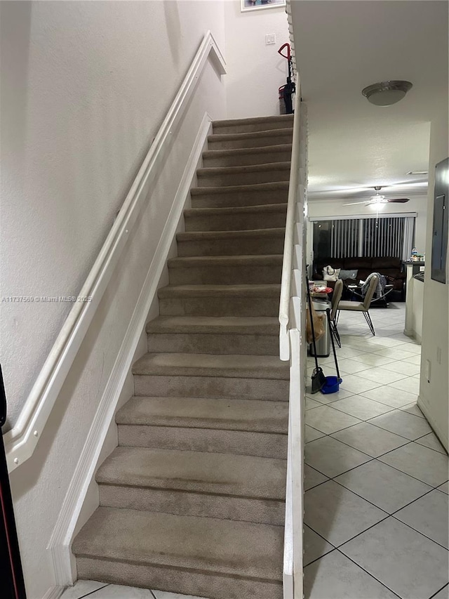 staircase featuring tile patterned flooring and a ceiling fan