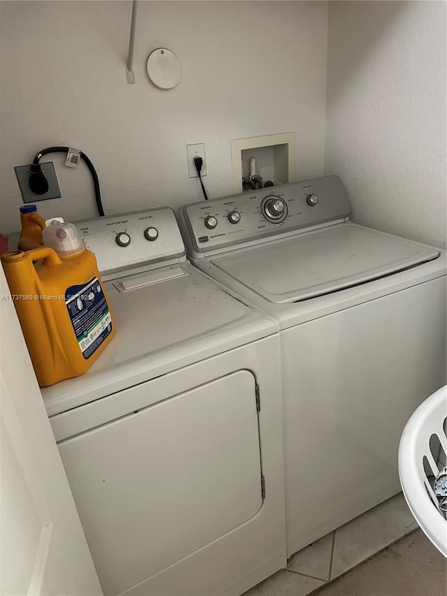 laundry area with independent washer and dryer, light tile patterned flooring, and laundry area