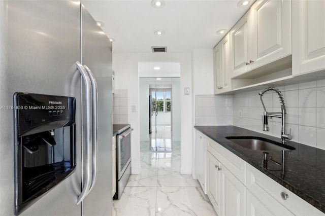 kitchen with visible vents, marble finish floor, tasteful backsplash, a sink, and appliances with stainless steel finishes