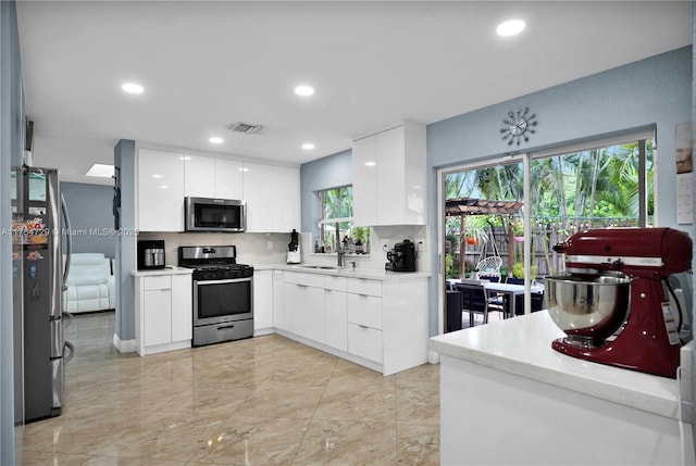 13021 NW 11th Ter, Miami, FL 33182 - kitchen with visible vents, modern cabinets, white cabinetry, stainless steel appliances, and light countertops